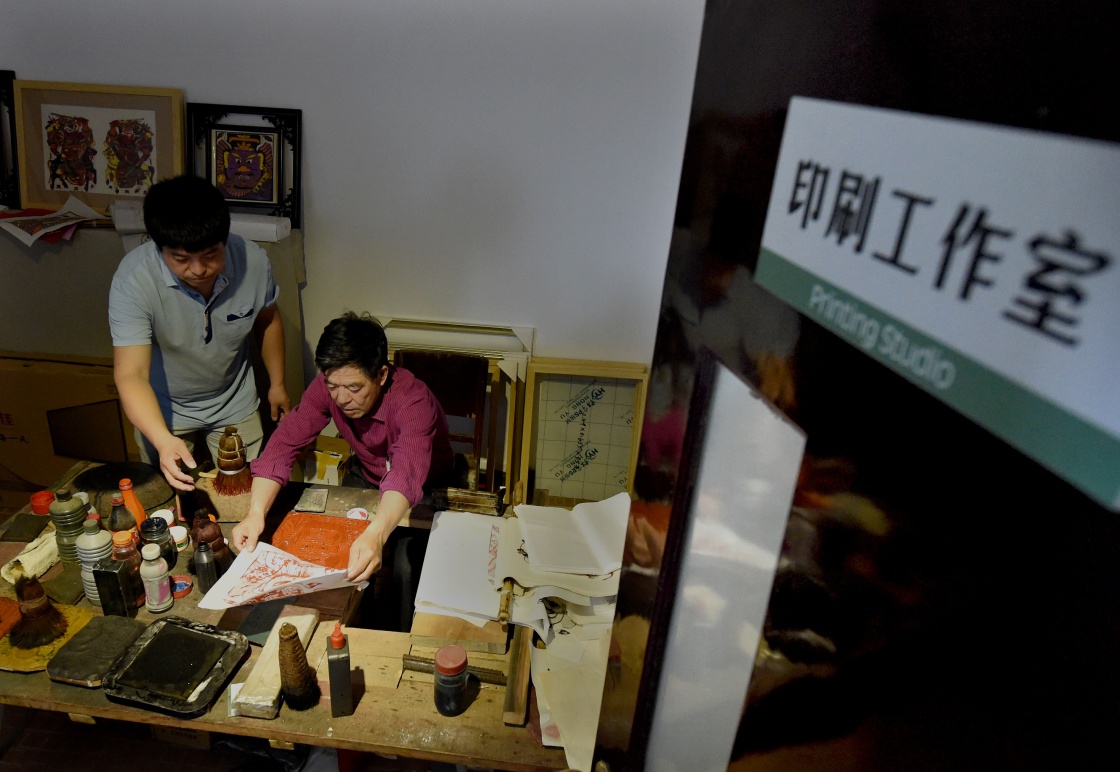 任鹤林父子在开封年画博物馆内的工作室中印製年画